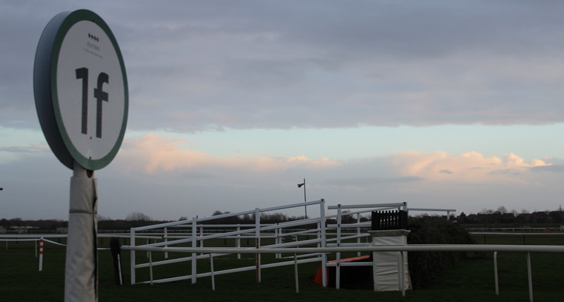 final furlong sign next to fence at race course